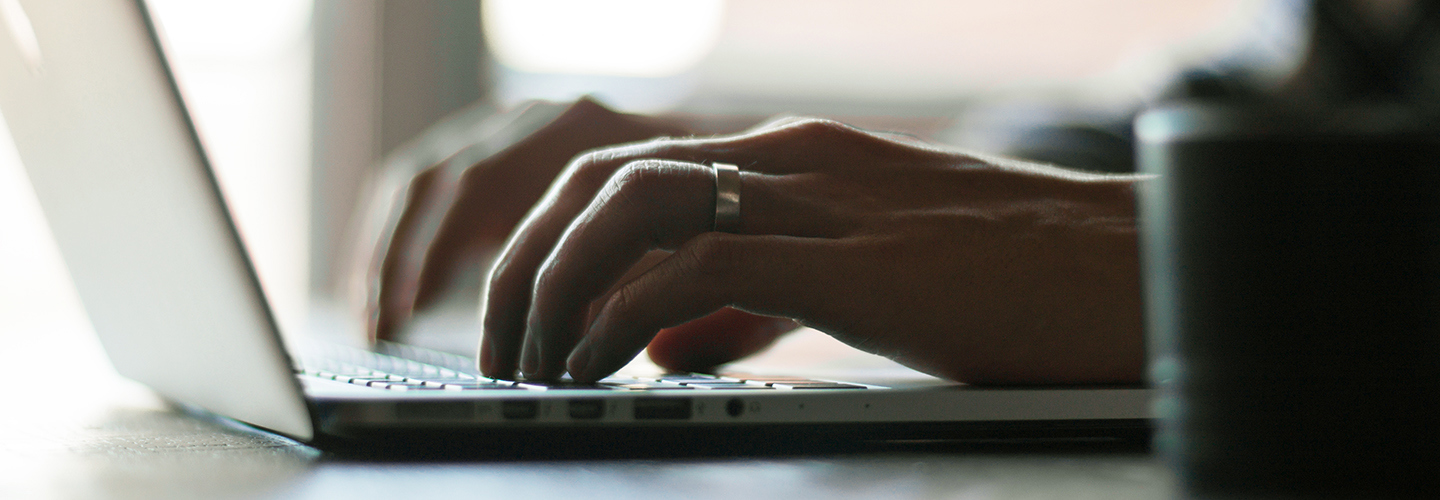 Hands typing on laptop